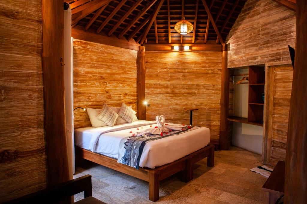 ein Schlafzimmer mit einem Bett in einem Zimmer mit Holzwänden in der Unterkunft Sunrise Paradise Bali in Karangasem