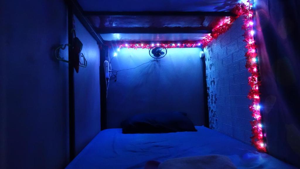 um quarto escuro com uma cama com luzes vermelhas em The Rendezvous Hostel em Haad Rin