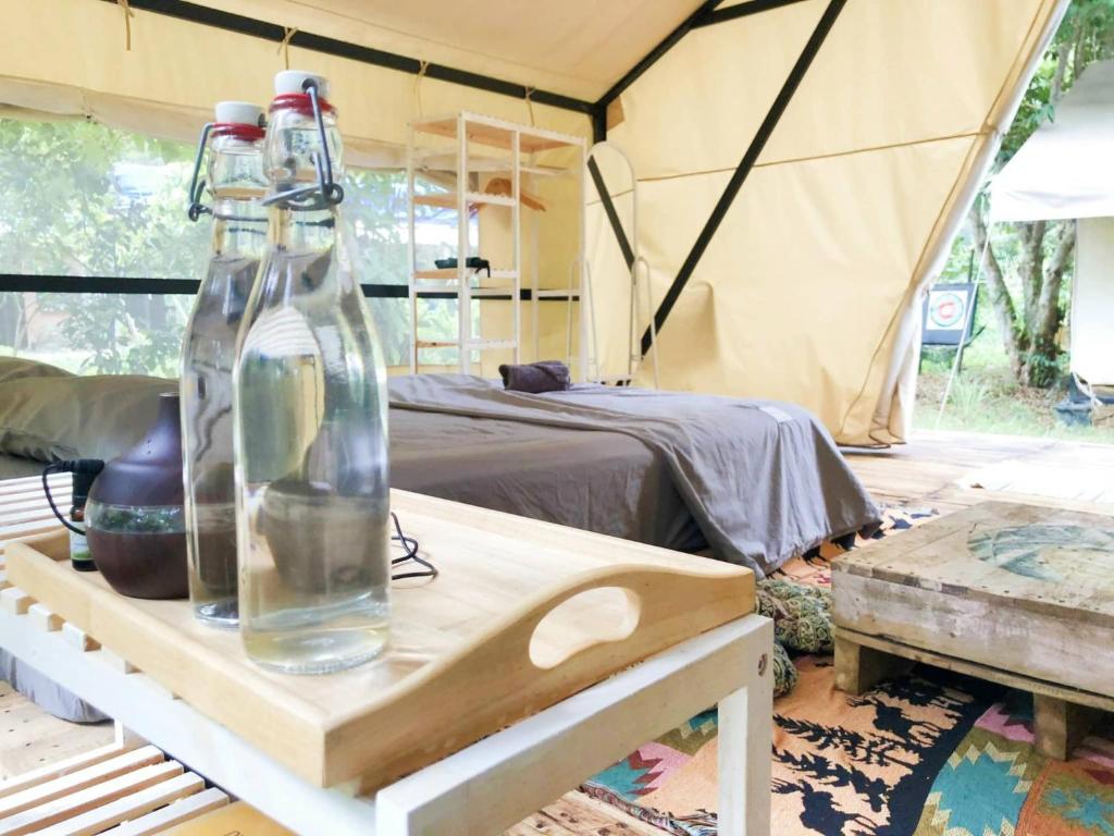 two glass bottles on a table in a tent at Con Dao Backpacker - LoCo Camping in Con Dao