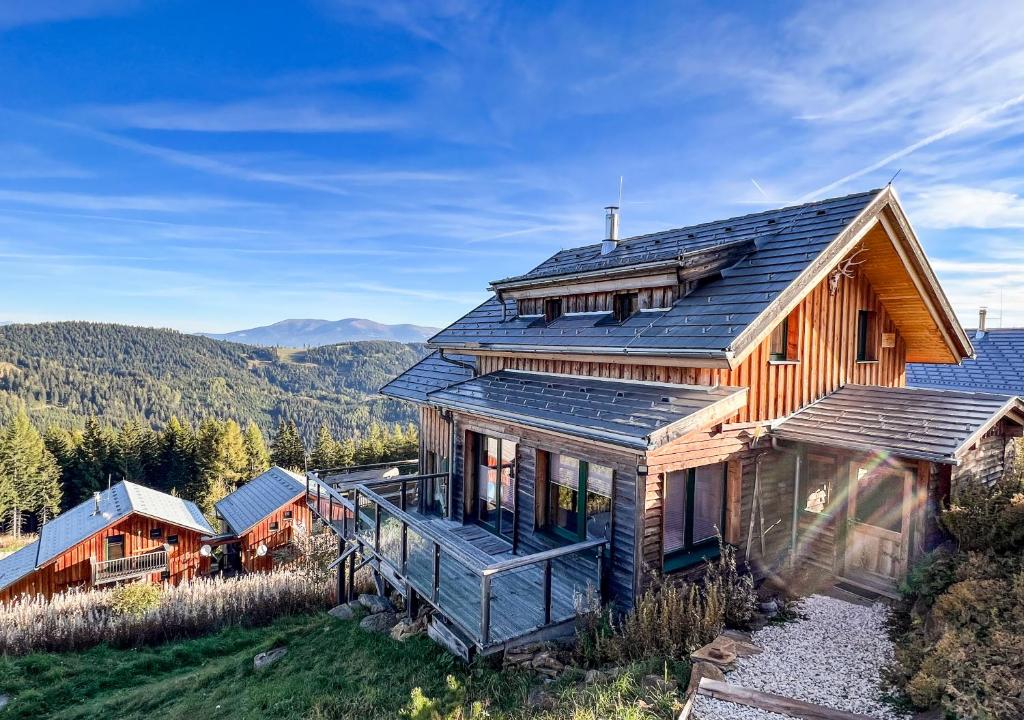 a wooden house with a solar roof on a hill at 1A Chalet "Wolke" Ski und Wellness im Traumhaus in Wolfsberg
