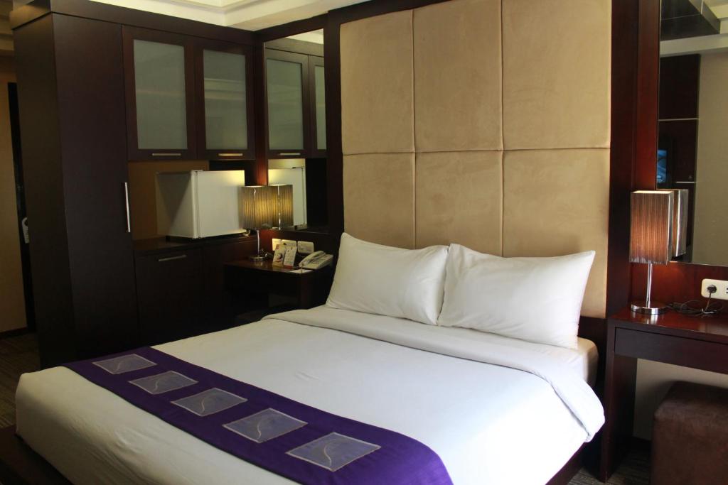 una camera con un grande letto bianco di Metro Hotel Jababeka a Cikarang