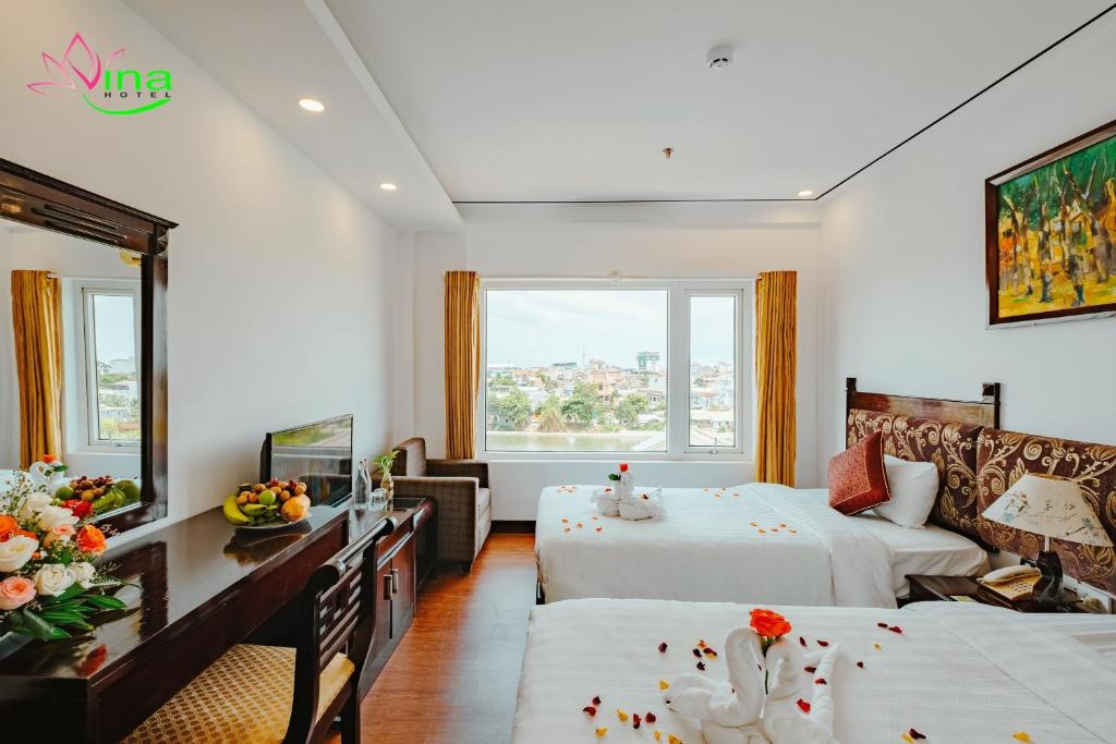 a hotel room with two beds and a desk at Vina Hotel Hue in Hue