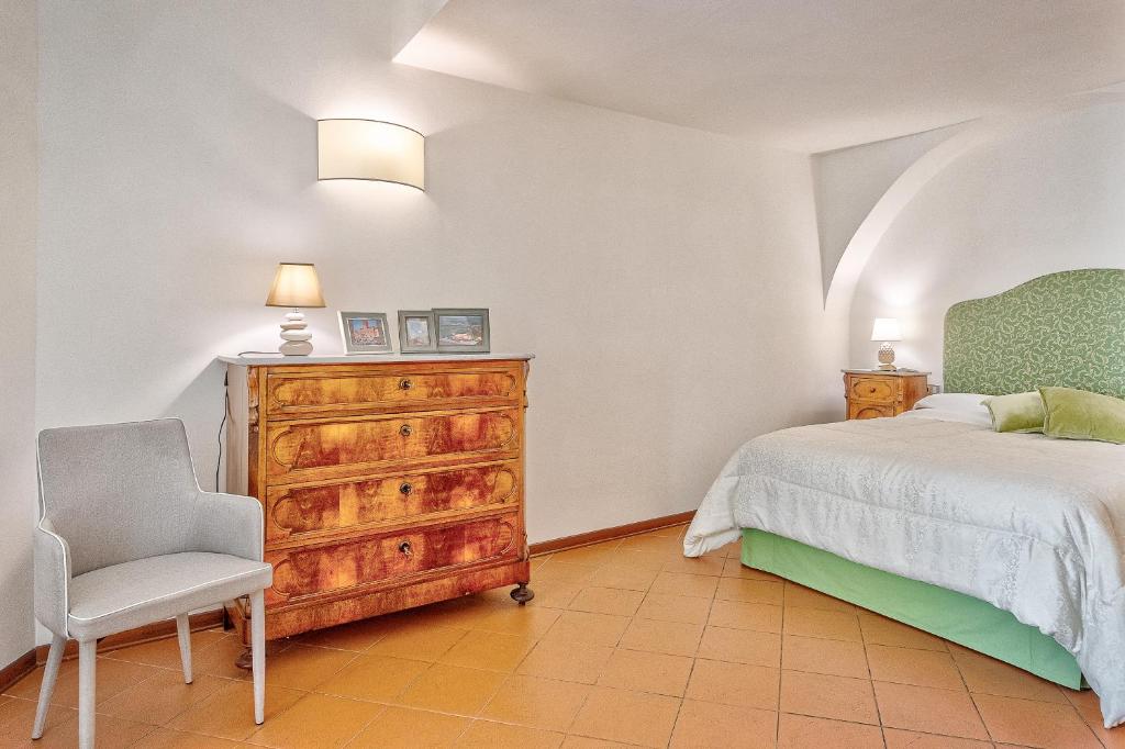 - une chambre avec un lit, une commode et une chaise dans l'établissement La Torretta - Together in Tuscany, à Cortone