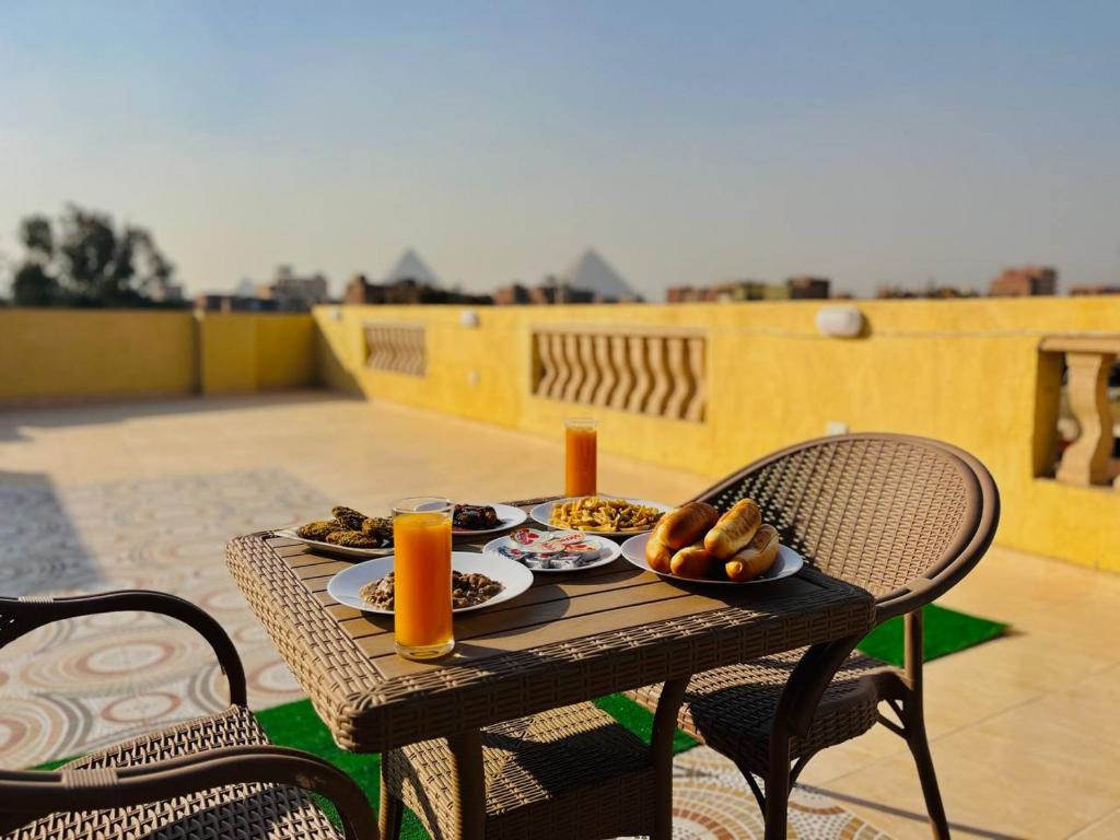 a table with plates of food on a balcony at Nefertiti guest house view pyramids in Cairo