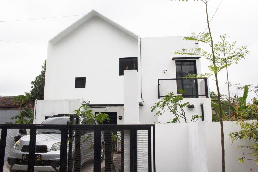 una casa blanca con un coche aparcado delante de ella en KLAB House - Guest House, en Yogyakarta