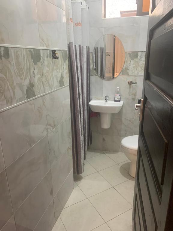 a bathroom with a shower and a sink and a toilet at Moraa’s Home in Mombasa