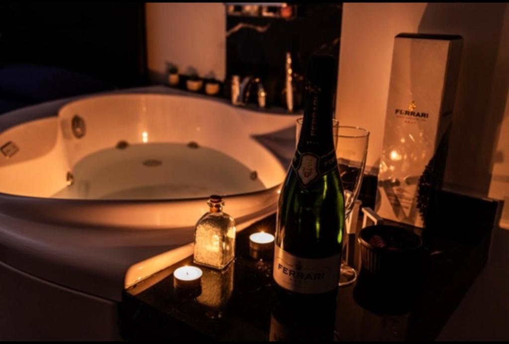 ein Badezimmer mit einer Badewanne und 2 Flaschen Wein in der Unterkunft SUITE CONCEPT ITALY in Casoria