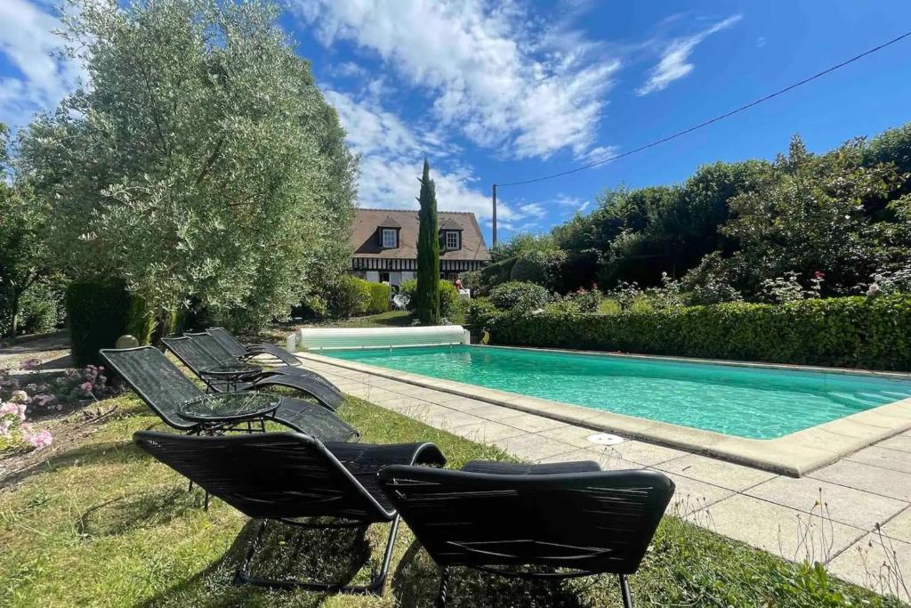 a group of chairs next to a swimming pool at Maddalena - Charming country villa for 10 people in Barneville-la-Bertrand