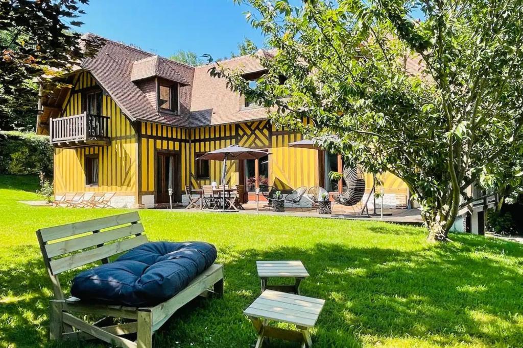 eine Bank, die im Gras vor einem Haus sitzt in der Unterkunft Eva Home Magnificent villa 4 Honfleur 10 P in Honfleur