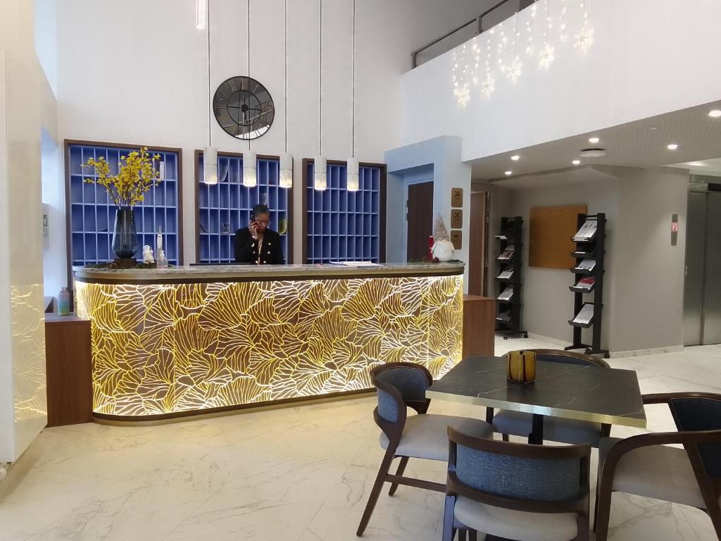 a woman standing behind a counter in a lobby at Domitys L'Ellipse in Paris