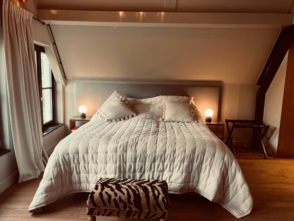 a bedroom with a bed with a white comforter at Townhouse 't Raap in Amsterdam
