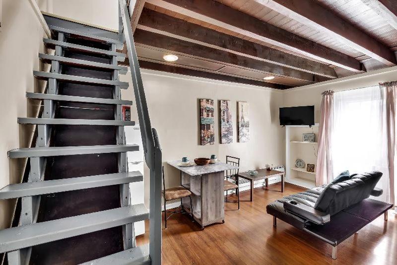 salon ze spiralnymi schodami i stołem w obiekcie Modern Loft Apartment In The Heart Of Center City w Filadelfii