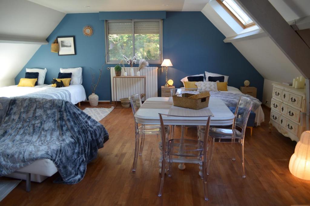 1 dormitorio con 2 camas, mesa y sillas en Le Copenhague en Lamorlaye