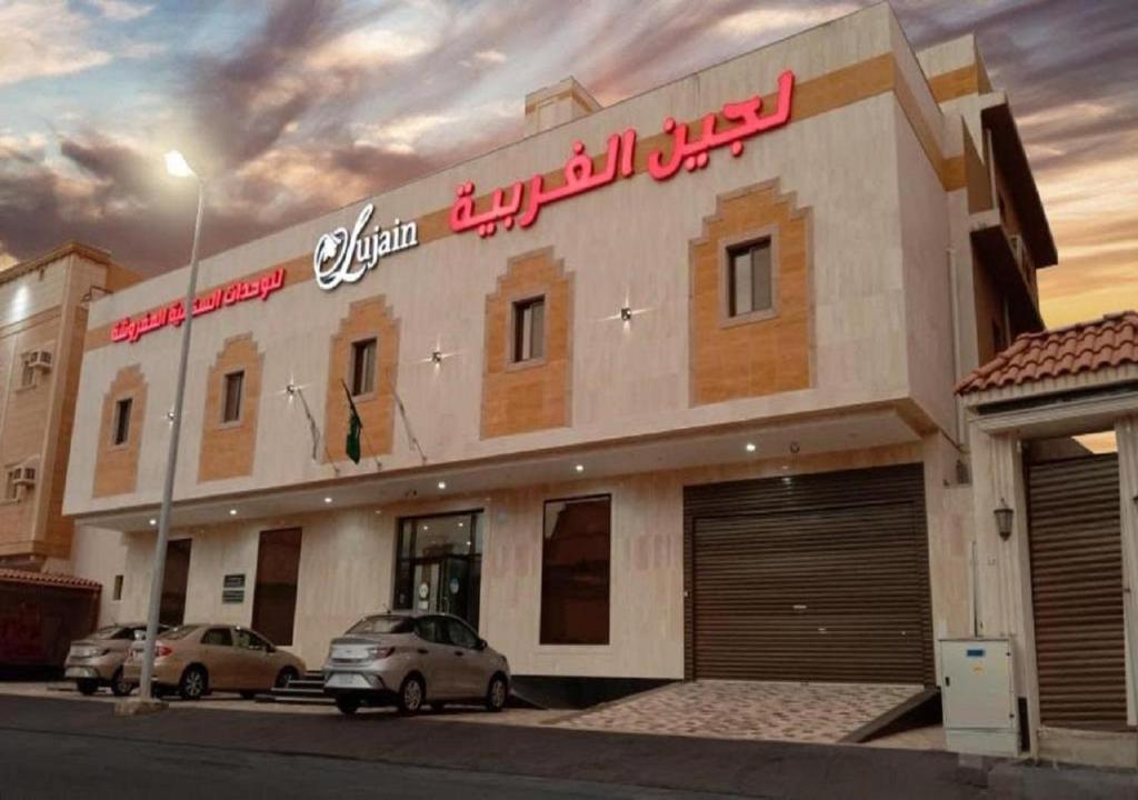 budynek z samochodami zaparkowanymi przed nim w obiekcie فندق لجين الغربية w mieście Dżudda