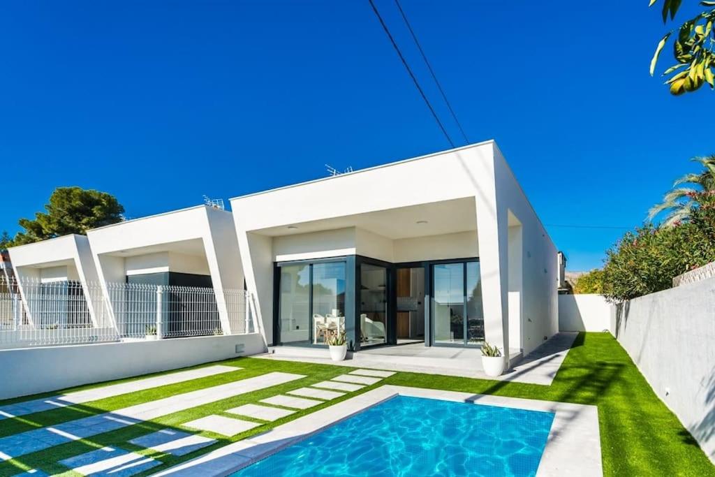 una casa blanca con piscina frente a ella en Maison neuve moderne en Los Baños