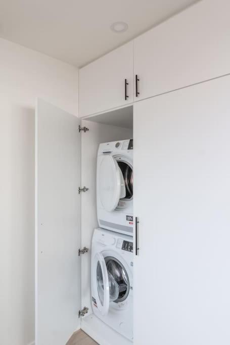 una lavanderia bianca con due lavasciuga di Classy flat with awesome view and great location! ad Anversa