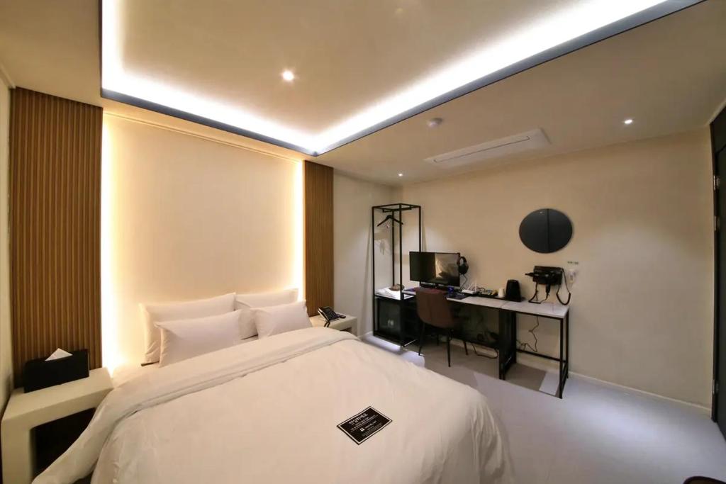 a bedroom with a large bed and a desk at Hotel141 in Daejeon