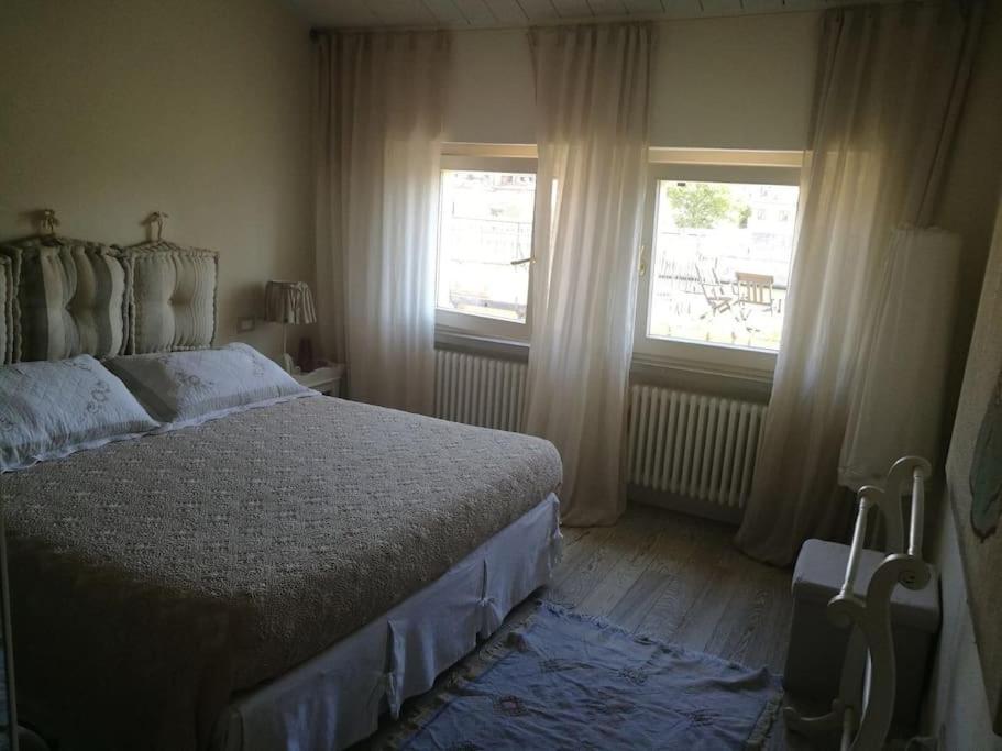 1 dormitorio con 1 cama y 2 ventanas en Appartamento nel romantico Borgo San Giuliano, en Rímini