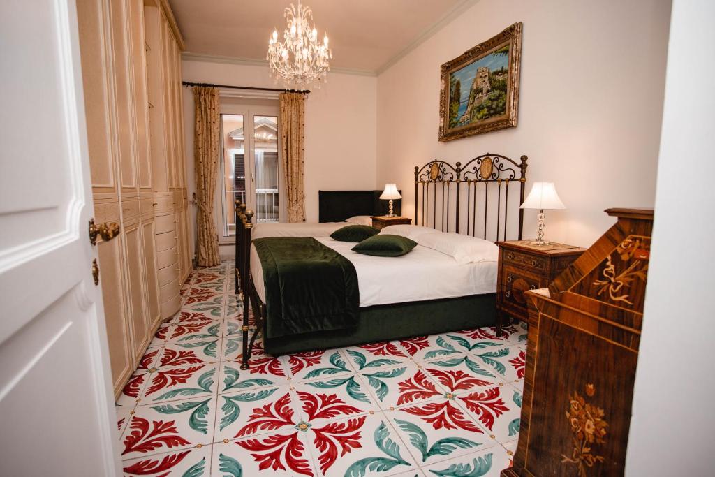 a bedroom with a bed and a chandelier at Delfini Trevi House in Rome