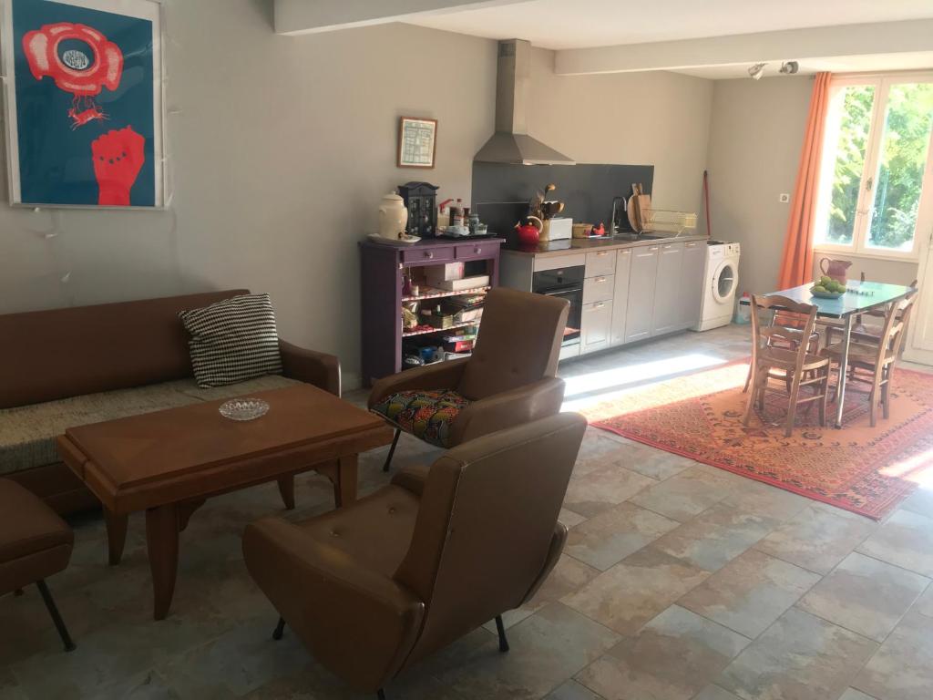 sala de estar con sofá y mesa en Studio avec jardin, en Coufouleux