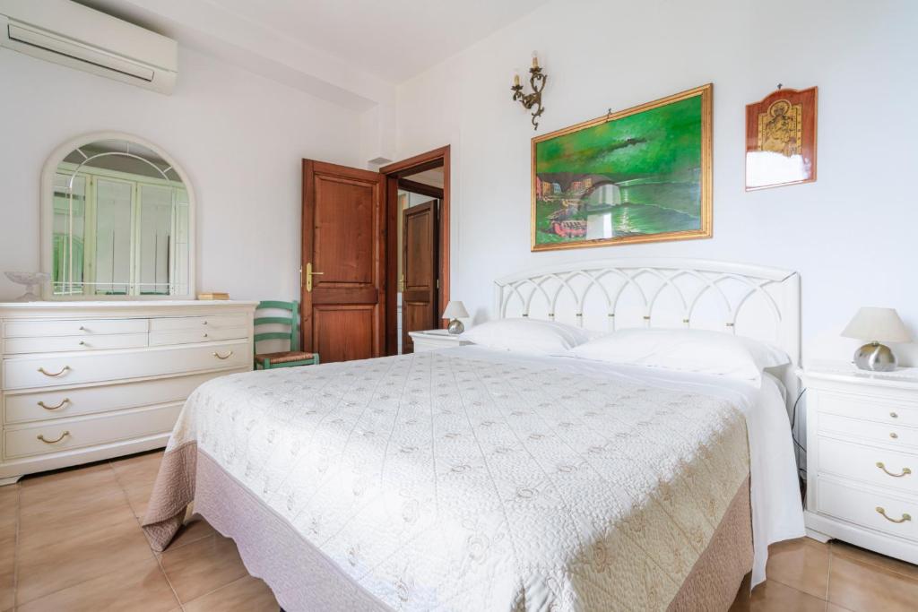 a white bedroom with a white bed and a dresser at Casa Danira - Positano in Positano