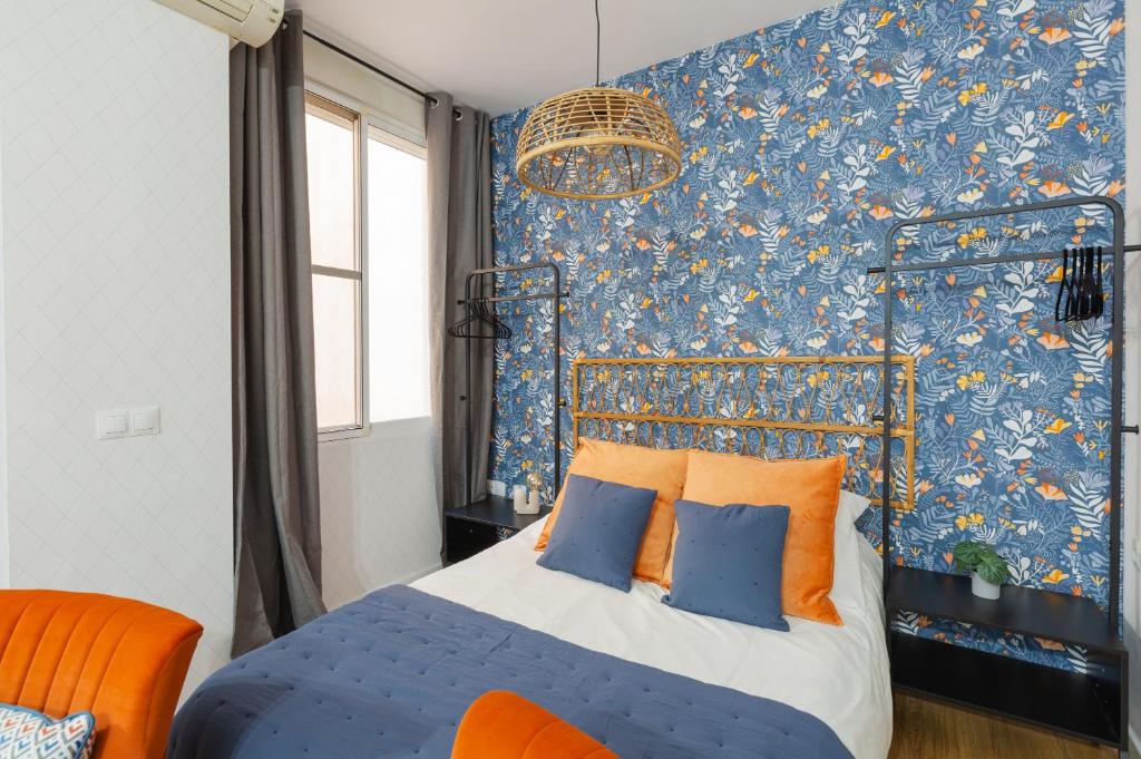 マラガにあるCasa Armoníaのベッドルーム1室(青とオレンジの枕が備わるベッド1台付)