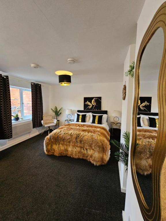ein Schlafzimmer mit einem großen Bett und einem großen Spiegel in der Unterkunft Deluxe Town Centre Studio Stevenage in Stevenage