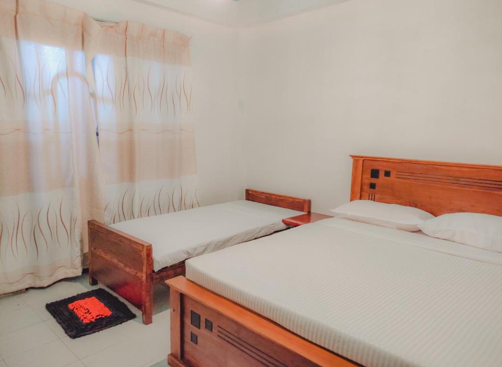 um quarto com duas camas e uma janela em The Pearl Homestay em Nugatalawa