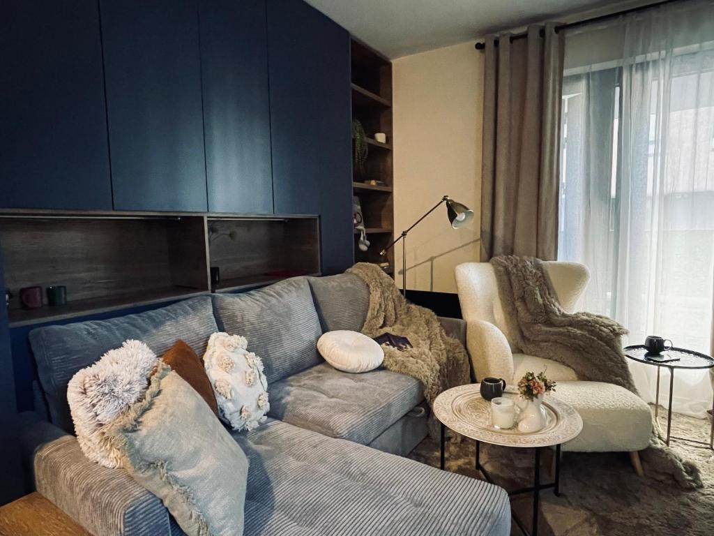 a living room with a couch and a chair at Ski, cocoa & novel apartment Bjelašnica, garage & ski room in Bjelašnica