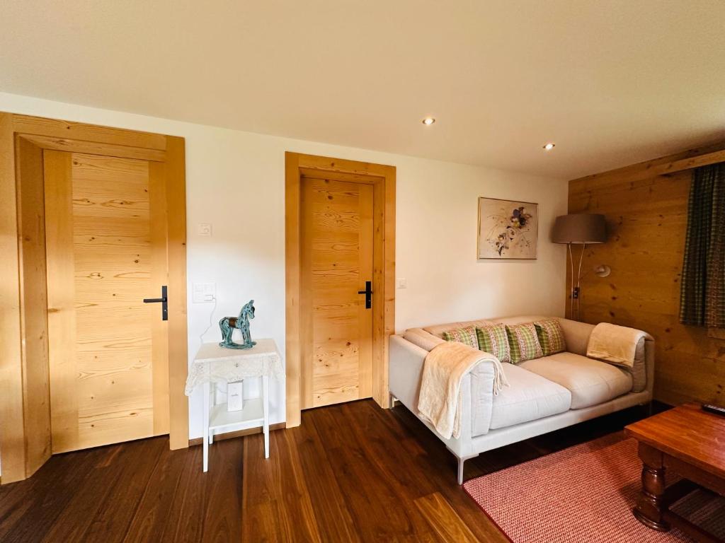 ein Wohnzimmer mit einem Sofa und einem Tisch in der Unterkunft Chalet Solaria 2 bedrooms with mountain and garden view in Zweisimmen