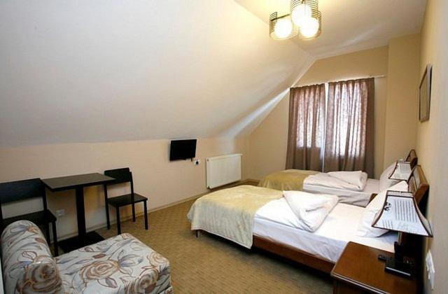 a hotel room with two beds and a desk at Hotel Abu in Gudauri