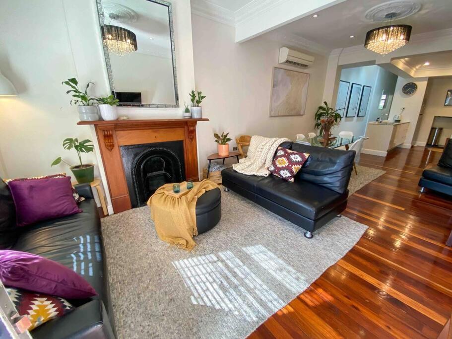 a living room with a couch and a fireplace at Immaculate 3 Bed City Home - Close to Everything! in Sydney