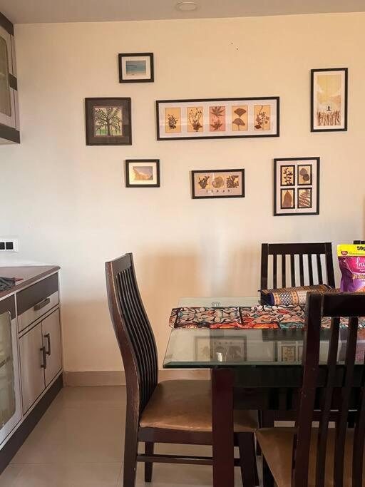 a dining room table with two chairs and a kitchen at Centrally located, big home in Kolkata