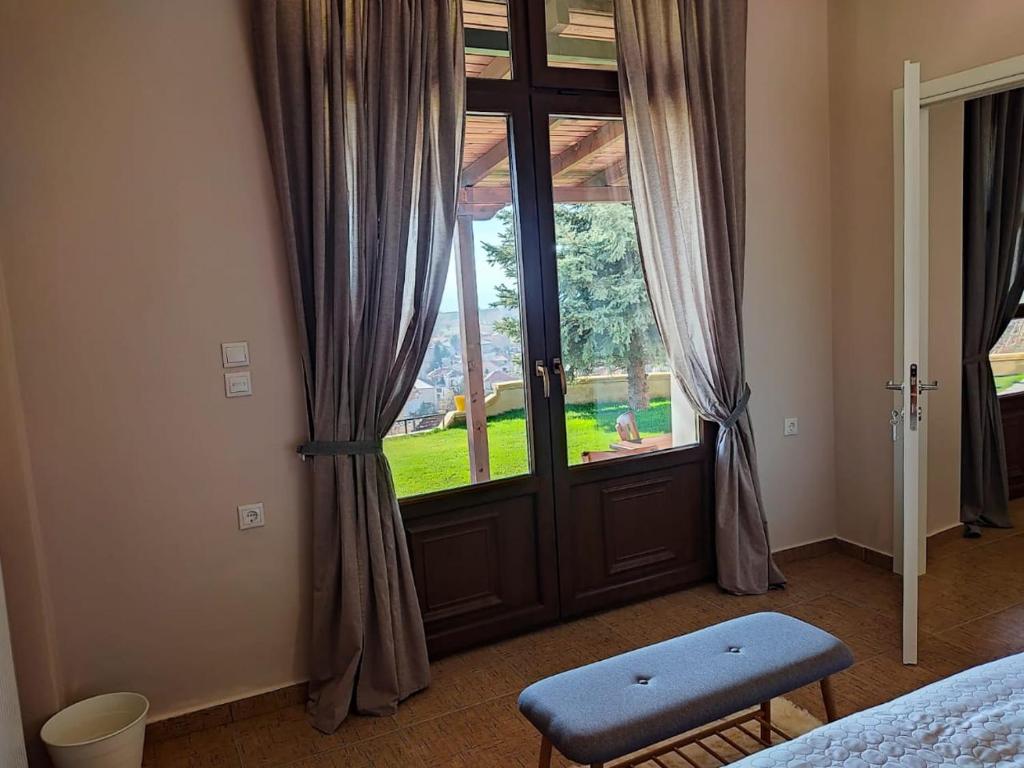a bedroom with a large glass door with a window at The Watch Tower in Siatista