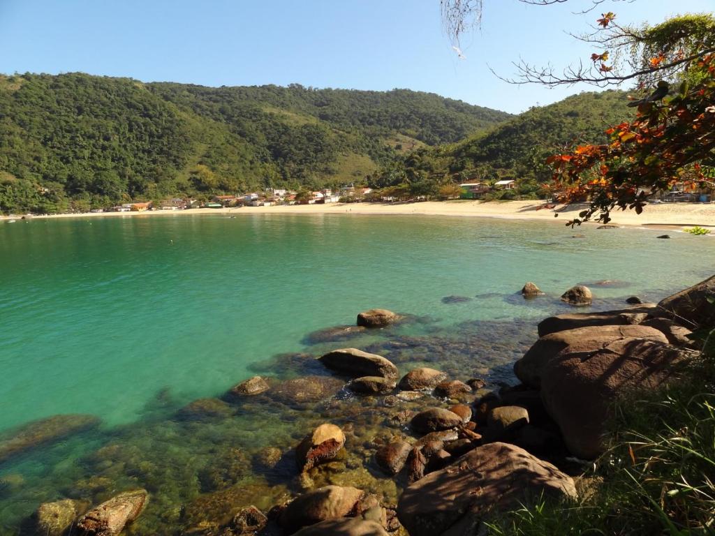 un cuerpo de agua con rocas y una playa en Suite Baia dos Corais Praia de Provetá Ilha Grande, en Angra dos Reis