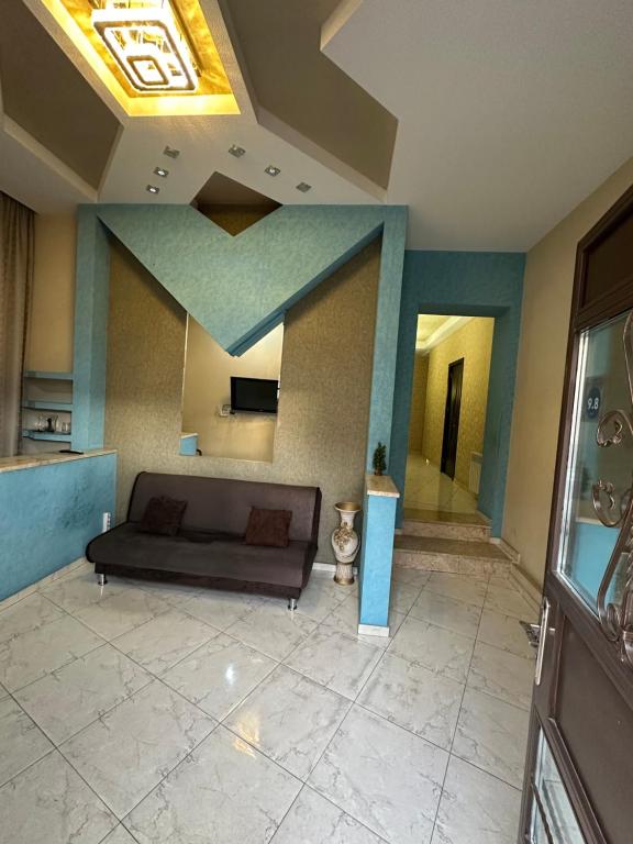 ein Wohnzimmer mit einem Sofa und einer Decke in der Unterkunft Hotel M.Classic in Tbilisi City