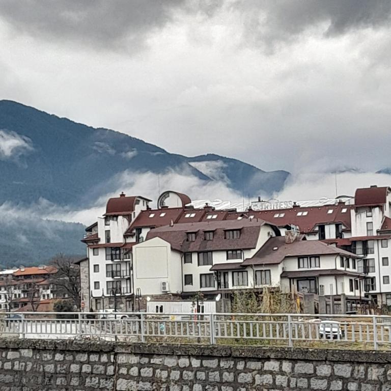 a group of buildings with mountains in the background at VIP apartmens Suvorov 1 in Bansko
