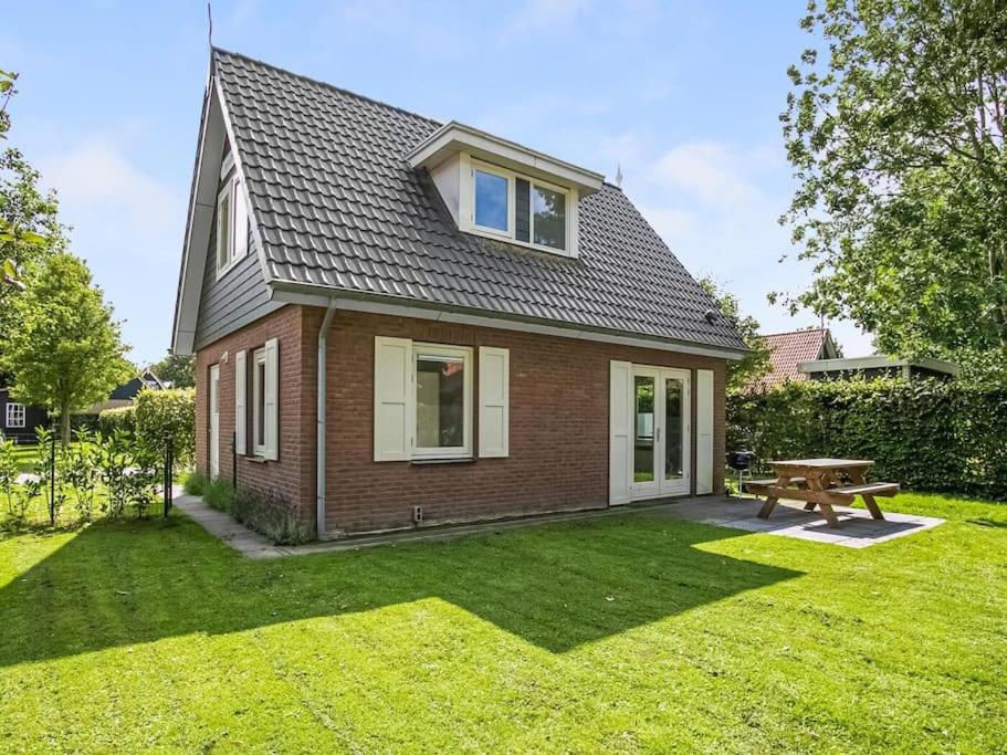 een klein huis met een picknicktafel in de tuin bij Holidayhouse Zeeland in Zonnemaire