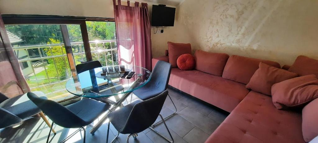een woonkamer met een rode bank en een glazen tafel bij Apartman Nevena Divčibare 2 in Divčibare