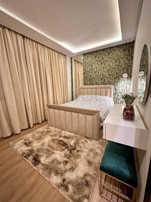 a bedroom with a bed and a table and a rug at LA Perle de la medina in Rabat