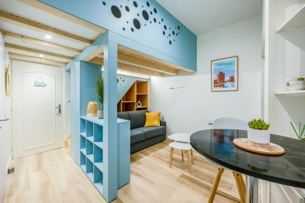 un salon avec un canapé bleu et une table dans l'établissement Charmant appartement à deux pas du Vieux-Port, à La Rochelle