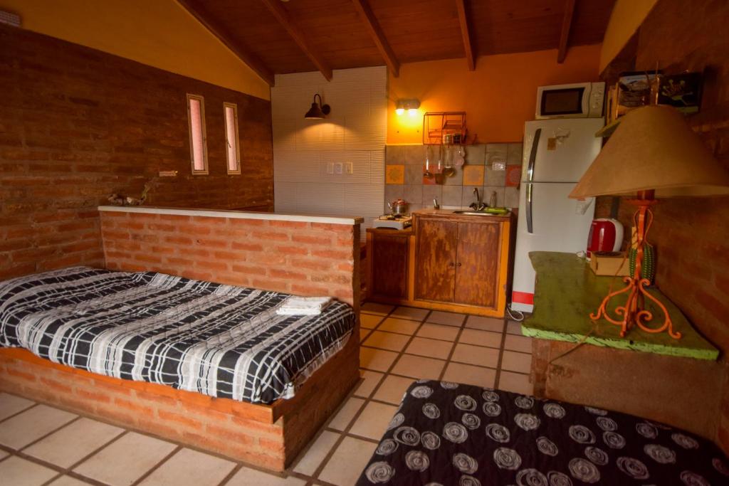 a bedroom with a bed and a kitchen in it at June en el Uritorco in Capilla del Monte