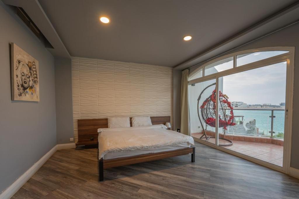 1 dormitorio con cama y ventana grande en فيلا على البحر درة العروس en Durat  Alarous