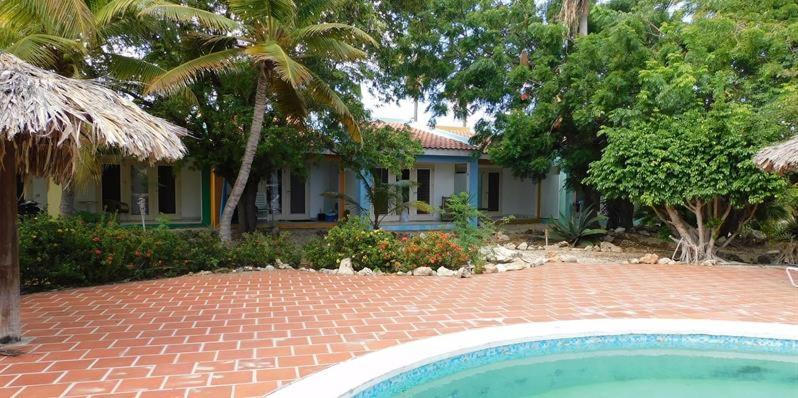 uma casa com um pátio de tijolos e uma piscina em Caribbean Court E1 em Kralendijk