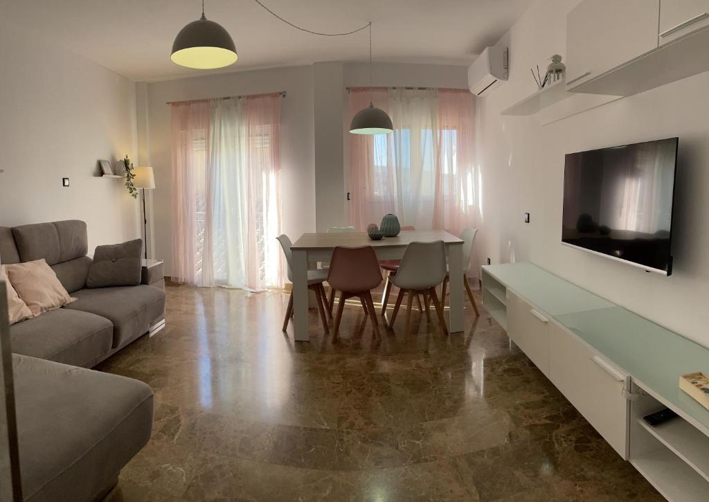 a living room with a couch and a table with chairs at Torre del reloj - Parking gratis in Cazorla