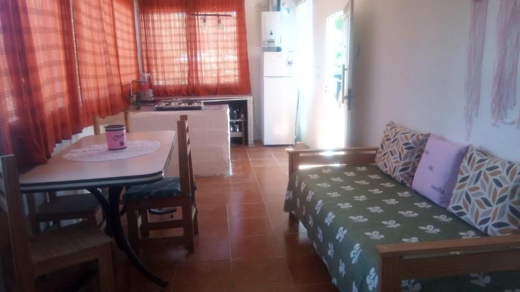 uma sala de estar com um sofá e uma mesa em Arriba y La escondida em Villa Gesell