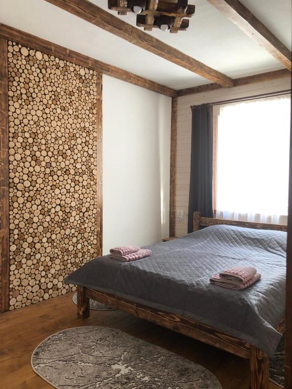 um quarto com uma cama e uma parede de troncos em Садиба Грицюка em Krivorovnya