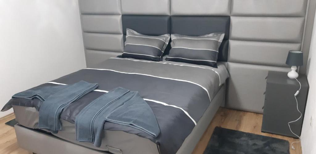 a bedroom with a bed with a headboard and pillows at LUX APARTMENT in Banja Luka