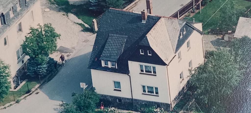 a large white house with a black roof at Ferienwohnung Schwarz in Lauter
