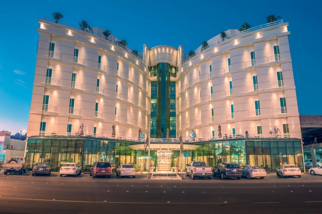 فندق فيلي Filly Hotel في حائل: مبنى فيه سيارات تقف امامه